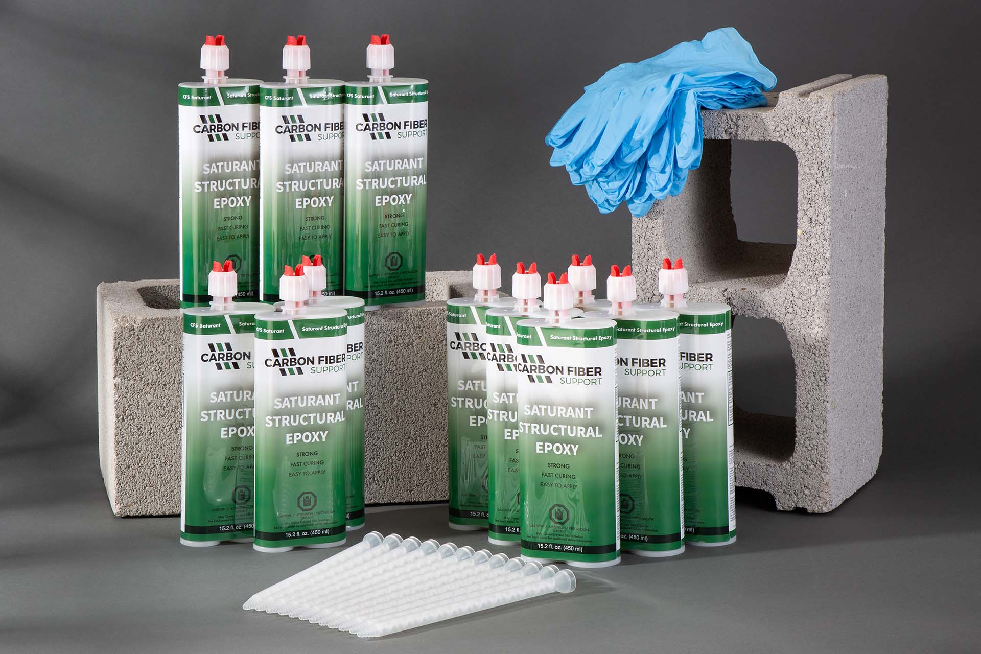 CFS Saturant Structural Epoxy Case of 12 shown displayed on cinder blocks with gloves.